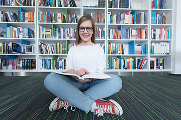 Image showing female student study in library, using tablet and searching for 