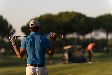 Image showing golfer from back at course looking to hole in distance