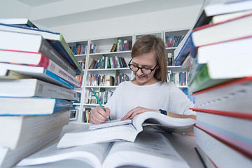 Image showing female student study in library, using tablet and searching for 