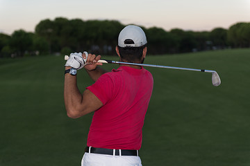 Image showing golfer hitting a sand bunker shot on sunset