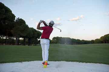 Image showing golfer hitting a sand bunker shot on sunset