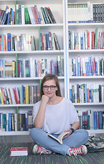 Image showing famale student reading book in library