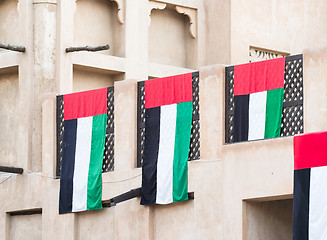 Image showing UAE flags on traditional house