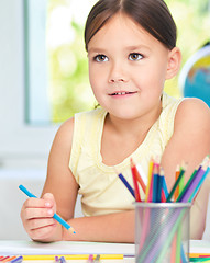 Image showing Little girl is drawing using pencils