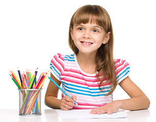 Image showing Little girl is drawing using pencils