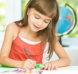 Image showing Little girl is drawing using pencils