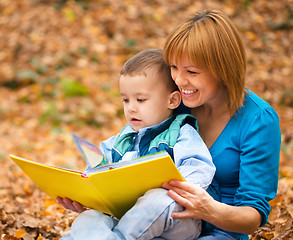 Image showing Mother is reading from tablet with her son