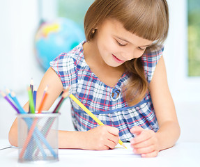 Image showing Little girl is drawing using pencils