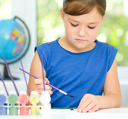 Image showing Little girl is painting with gouache