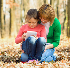 Image showing Mother is reading from tablet with her daughter