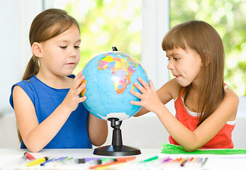 Image showing Little girls are examining globe