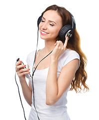 Image showing Young woman enjoying music using headphones