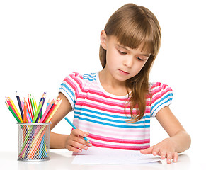 Image showing Little girl is drawing using pencils