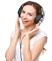 Image showing Young woman enjoying music using headphones