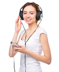 Image showing Young woman enjoying music using headphones