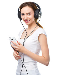 Image showing Young woman enjoying music using headphones