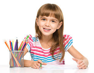 Image showing Little girl is drawing using pencils