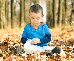 Image showing Little boy is reading book