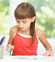 Image showing Little girl is drawing using pencils