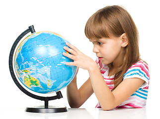 Image showing Little girl is examining globe