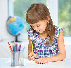 Image showing Little girl is drawing using pencils