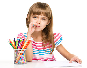 Image showing Little girl is drawing using pencils