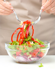 Image showing Cook is mixing salad