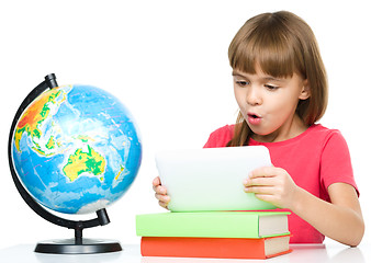 Image showing Young girl is using tablet while studying