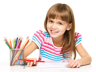 Image showing Little girl is drawing using pencils