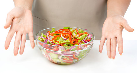 Image showing Cook is presenting fresh salad