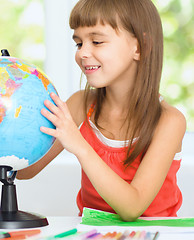 Image showing Little girl is examining globe
