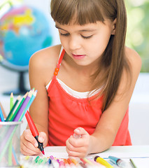 Image showing Little girl is drawing using pencils