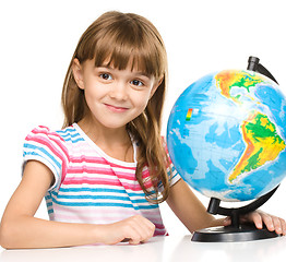 Image showing Little girl is examining globe