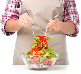 Image showing Cook is mixing salad