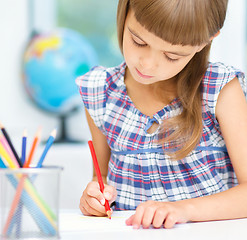 Image showing Little girl is drawing using pencils