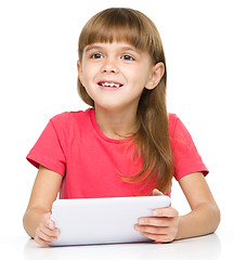 Image showing Young girl is using tablet