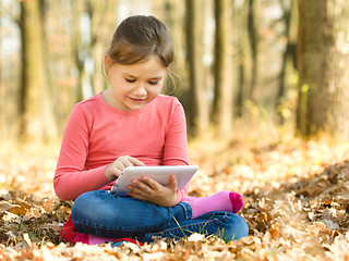 Image showing Little girl is reading from tablet