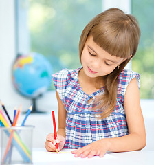 Image showing Little girl is drawing using pencils