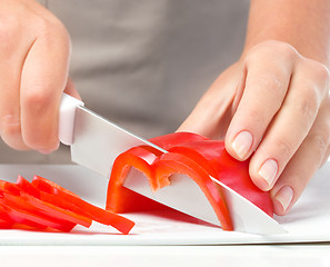 Image showing Cook is chopping bell pepper