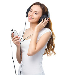 Image showing Young woman enjoying music using headphones