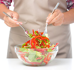 Image showing Cook is mixing salad