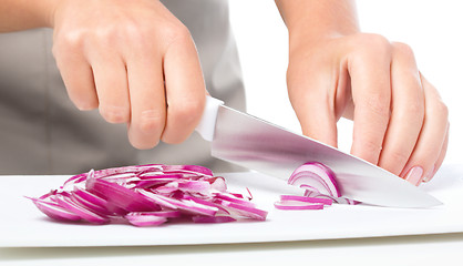 Image showing Cook is chopping onion