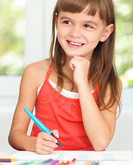 Image showing Little girl is drawing using pencils