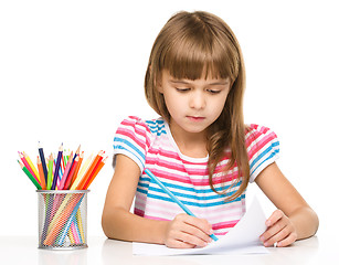 Image showing Little girl is drawing using pencils