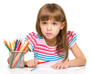 Image showing Little girl is drawing using pencils