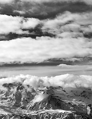 Image showing Black and white sunlight snowy mountains in clouds