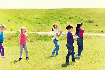 Image showing group of kids catching soap bubbles outdoors