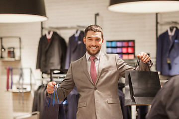 Image showing happy man with shopping bags at clothing store