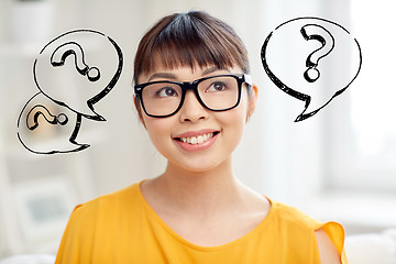 Image showing happy asian woman in glasses over question marks