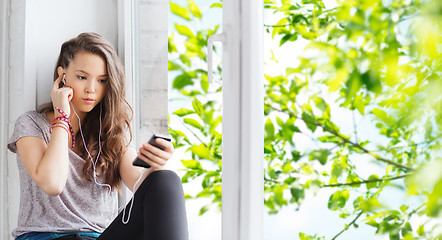 Image showing teenage girl with smartphone and earphones